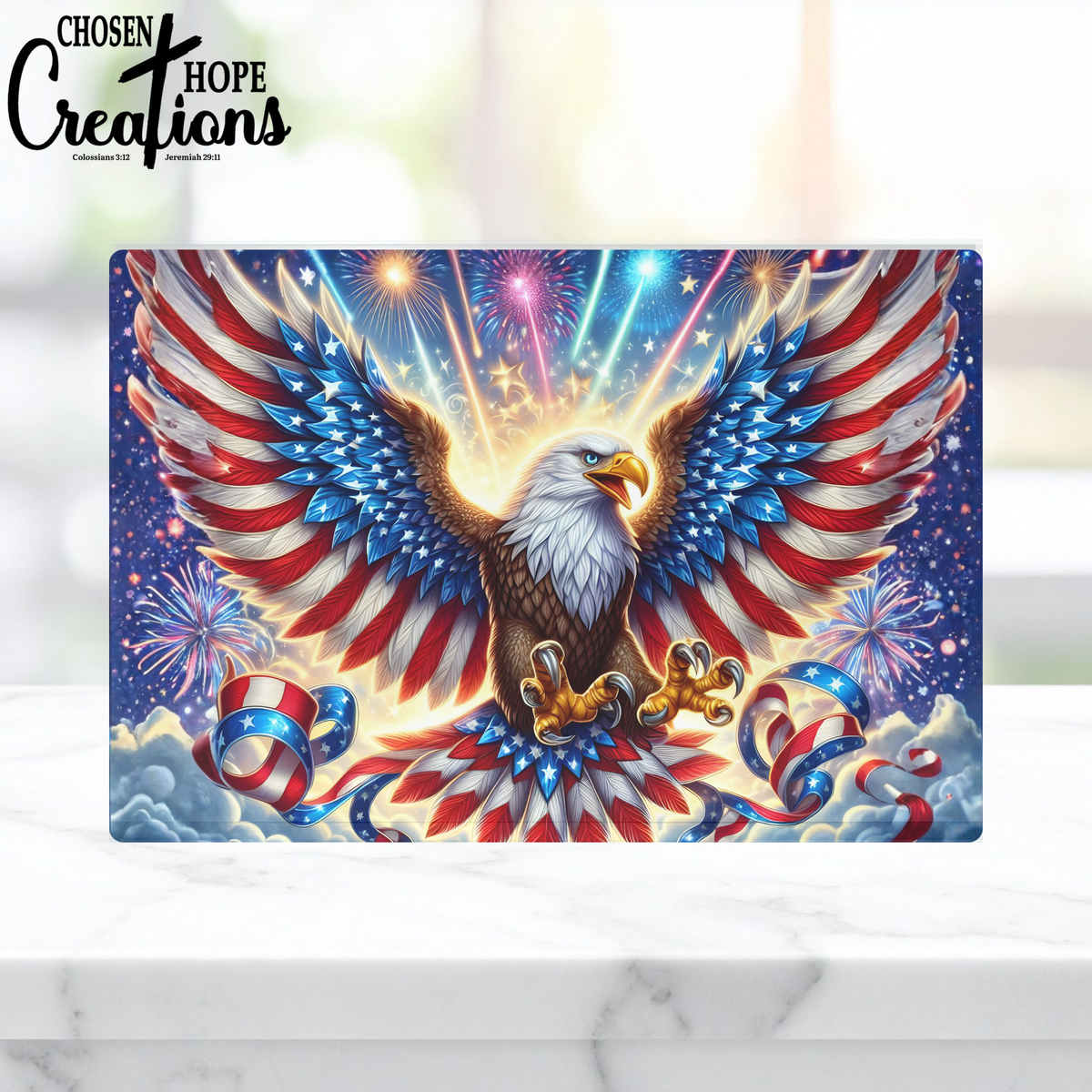 Decorative glass cutting board with an eagle design featuring American flag colors and fireworks on a white marble surface.